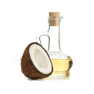 a coconut half next to a bottle of oil